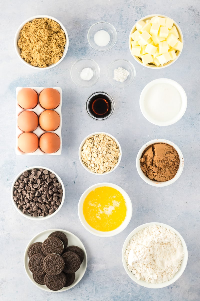 Ingredients for Oreo stuffed chocolate chip cookies bars in small bowls on counter.
