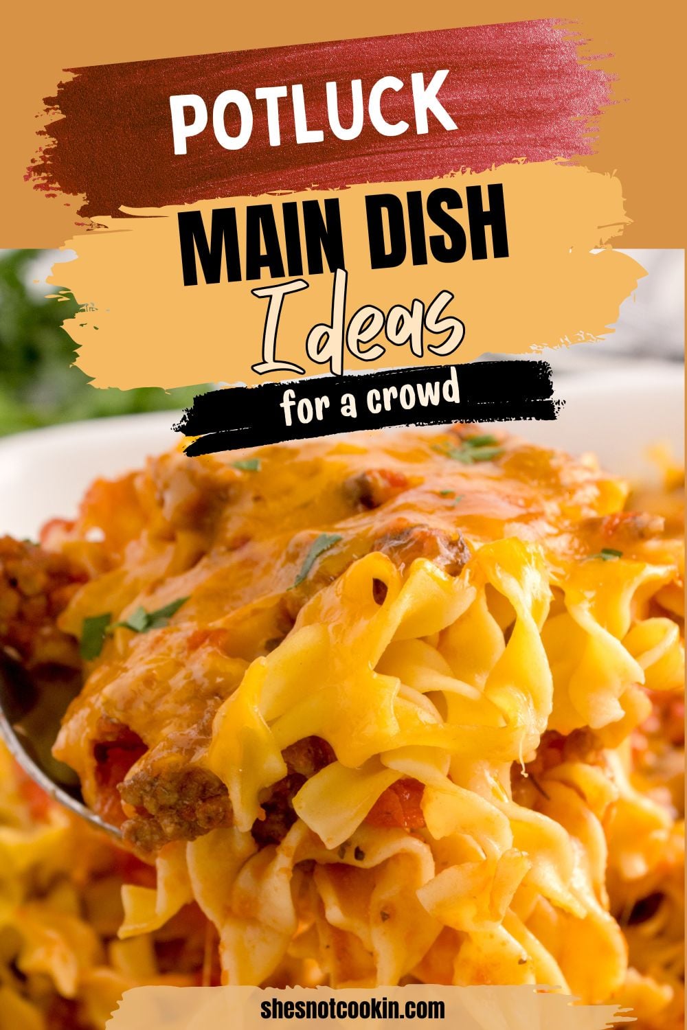Beef noodle casserole scooped up on a spoon held over the cheesy casserole.