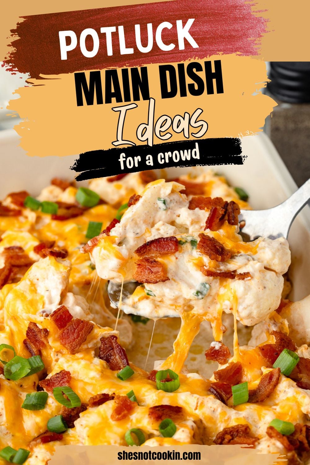 Loaded cauliflower casserole scooped up on a spoon held over baking dish.