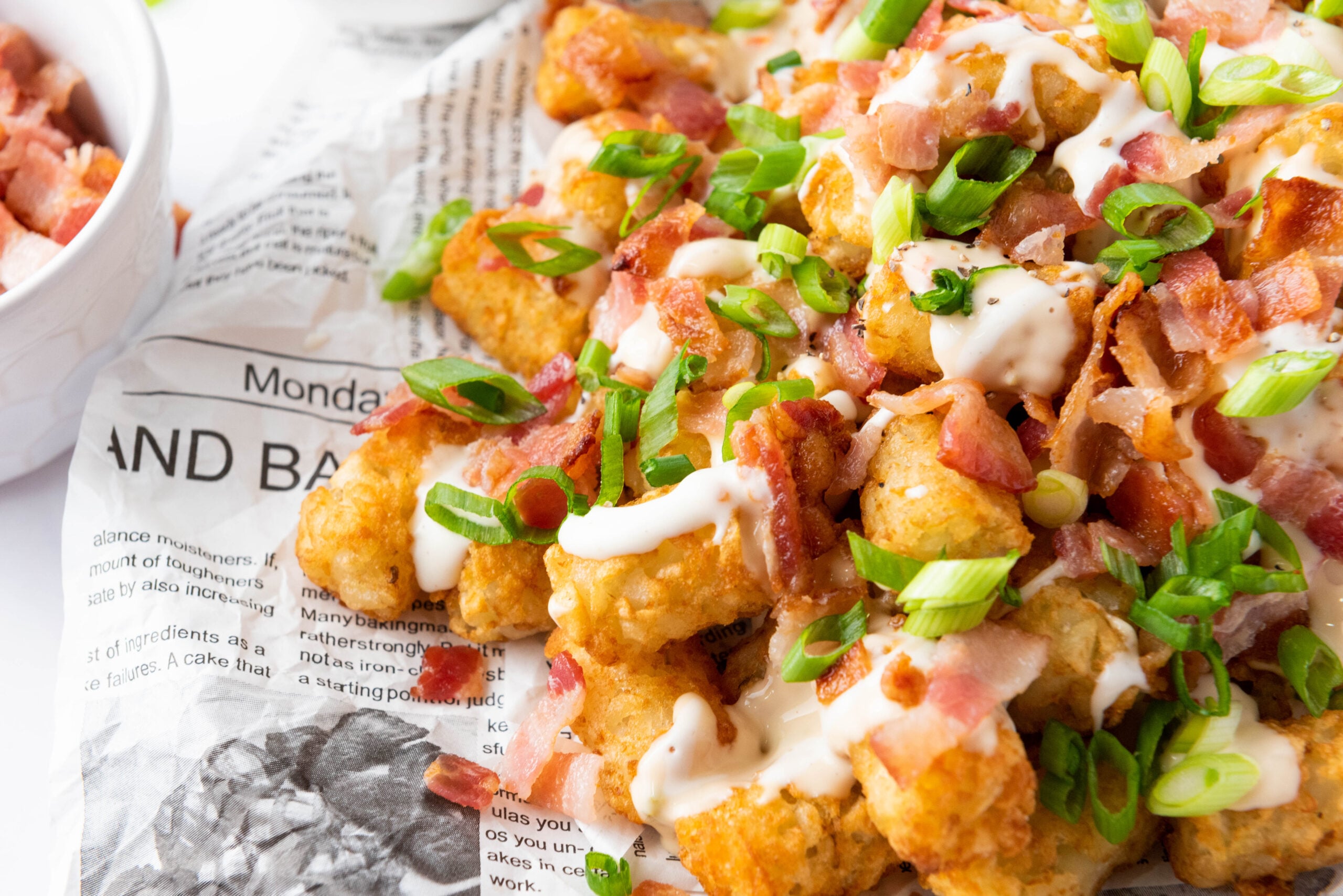 Loaded tater tots served on a plate.