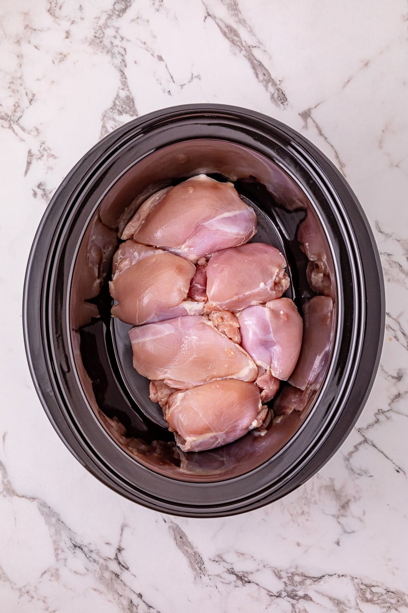 Chicken thighs place in bottom of crockpot.