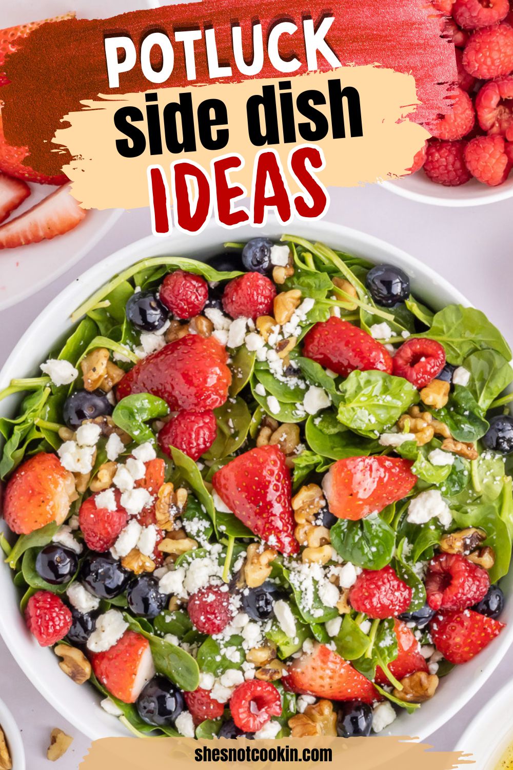 Spinach & berry salad served in a white bowl.