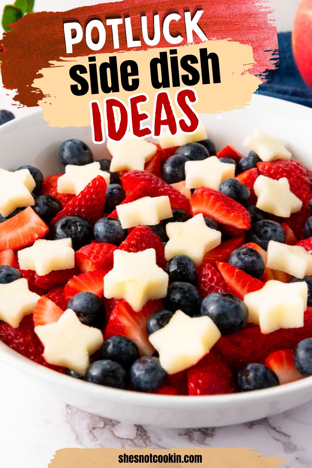 Red white and blue fruit salad in a white bowl.