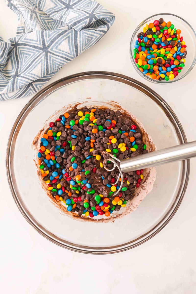 Chocolate chips and half of the M&M's are adde to the cake batter.