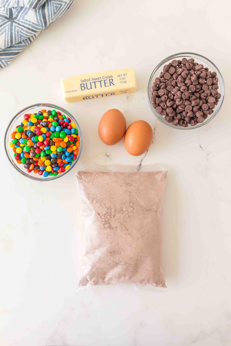 Ingredients for cake mix brownies laid out in small bowls on counter.