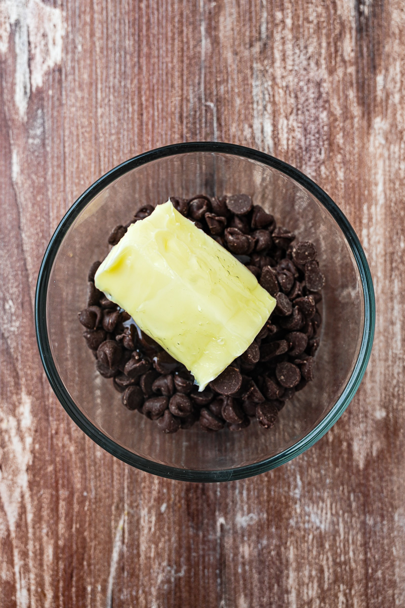 Chocolate chips and butter in glass bowl.