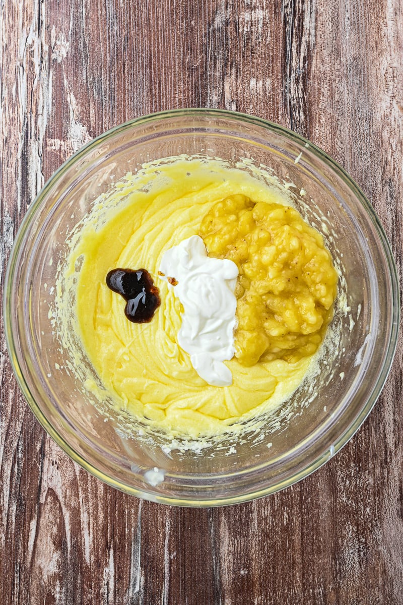 Bananas, sour cream and vanilla are added to the mixing bowl.