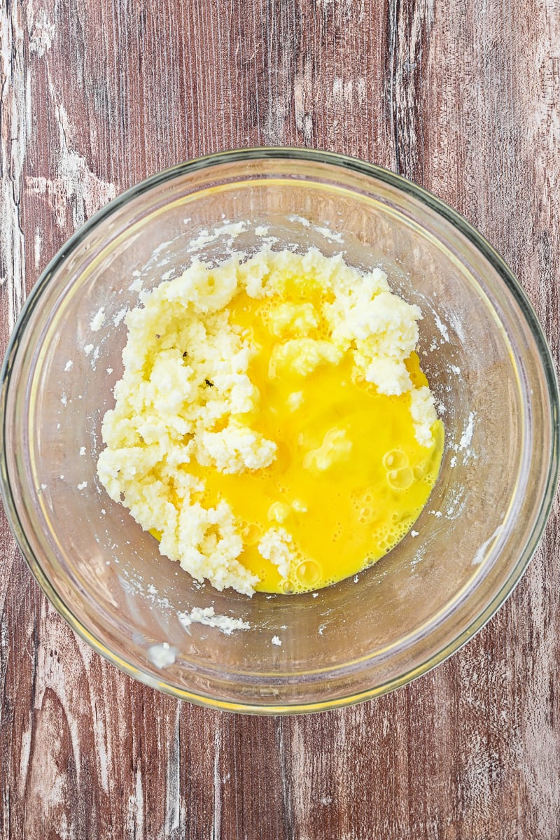 Eggs are added to the mixing bowl with the creamed sugar and butter.