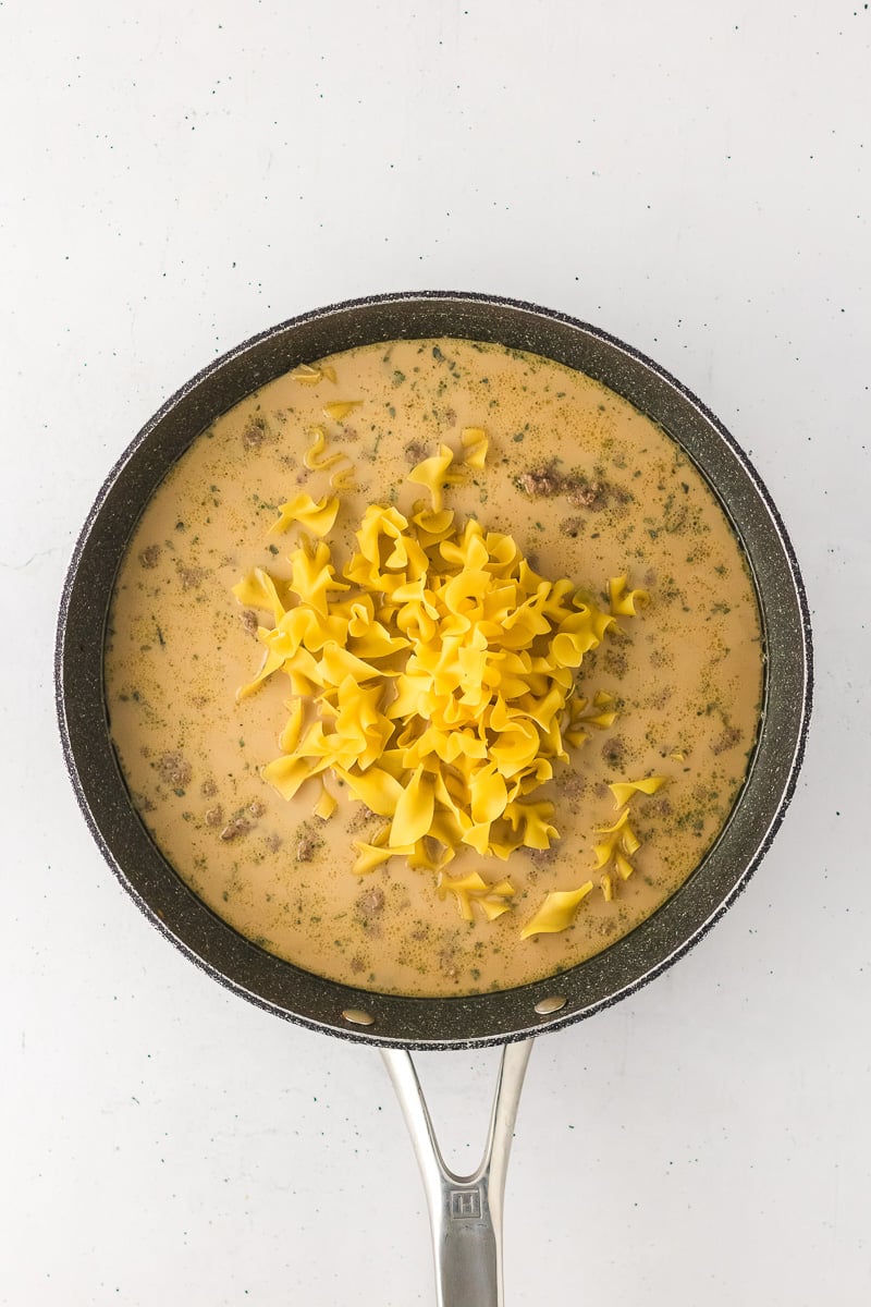 Egg noodles are added to the pan.