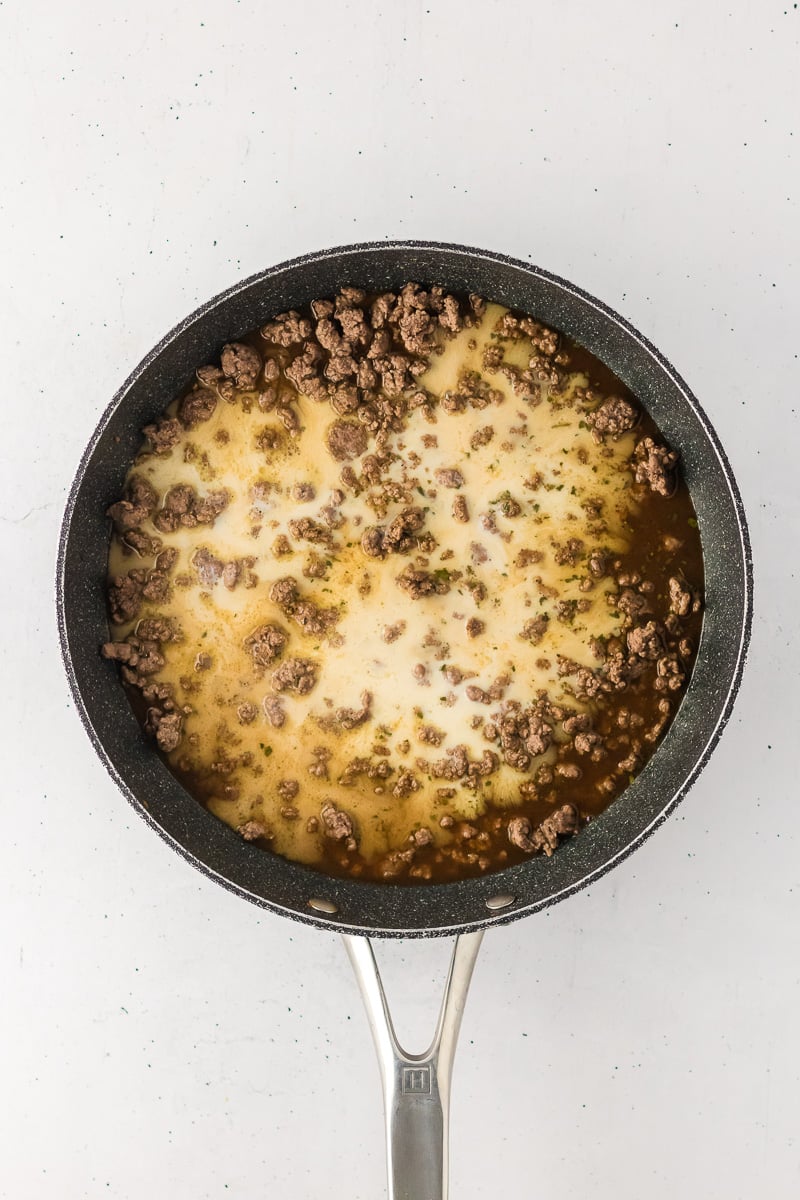 Spice mixutre & milk are added to the pan of cooked ground beef.