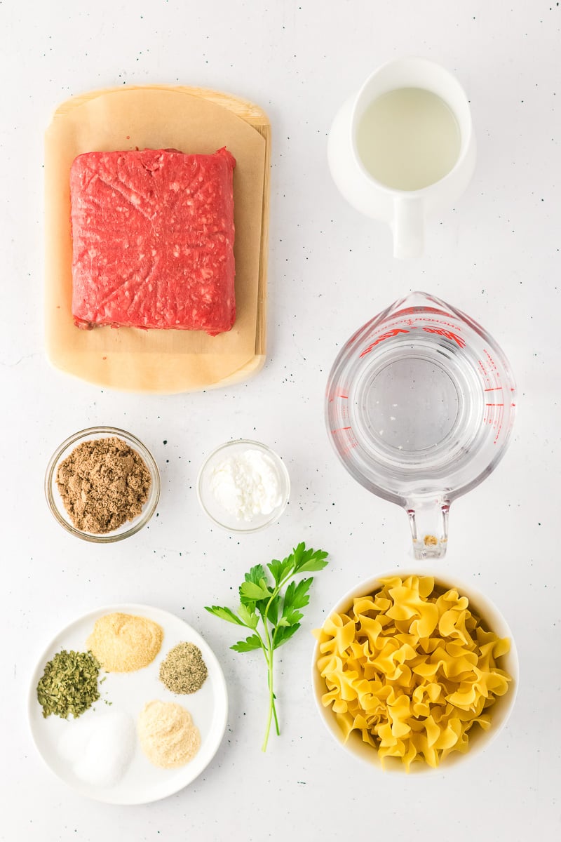 Ingredients for beef noodle hamburger helper laid out in small bowls on counter.