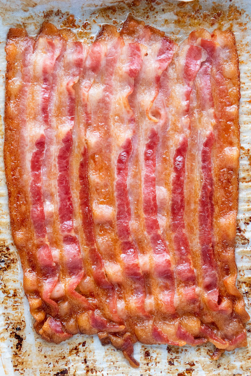 Cooked bacon on baking sheet ready to be cut into pieces.