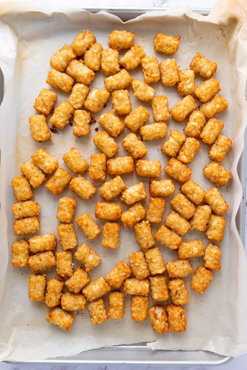 Cooked tater tots on baking sheet.