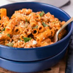 Creamy sausage rigatoni in a blue bowl.