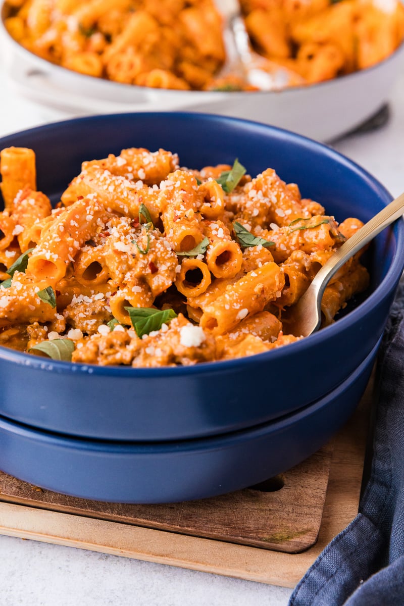 Creamy sausage rigatoni in a blue bowl.