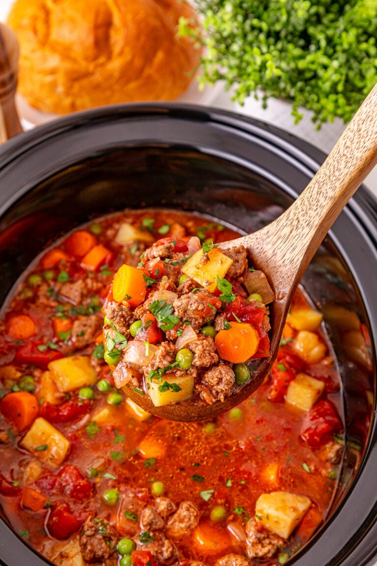 Poor man's stew scooped up and held over slow cooker.