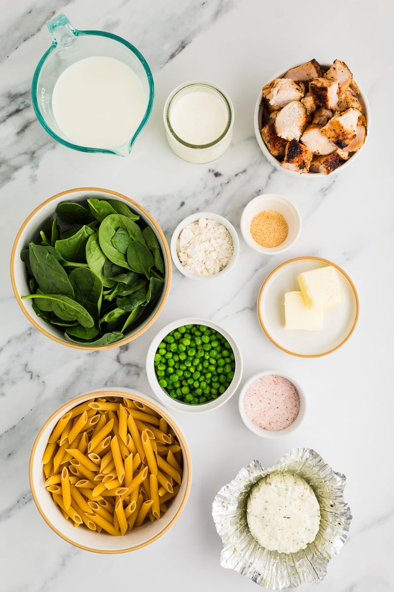 Ingredients for Boursin pasta with chicken in small bowls on counter.