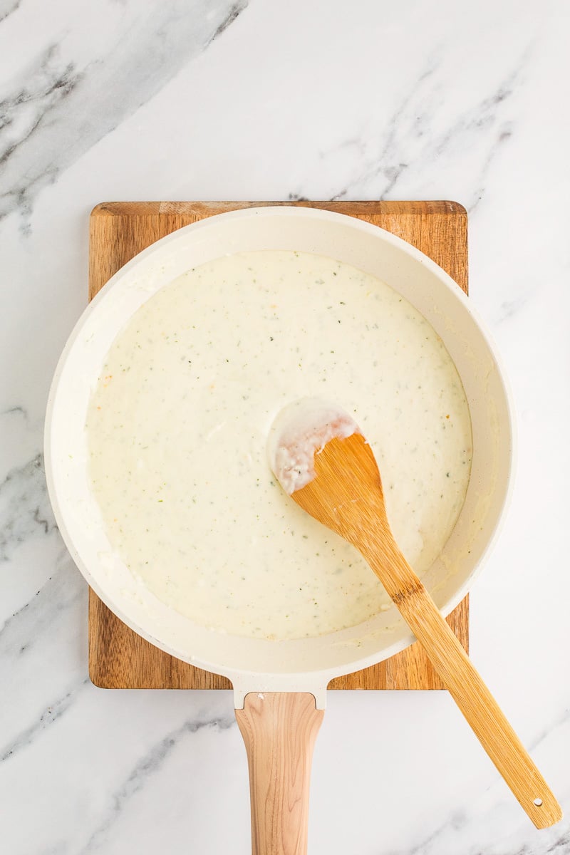 Milk and heavy cream is added to the skillet.