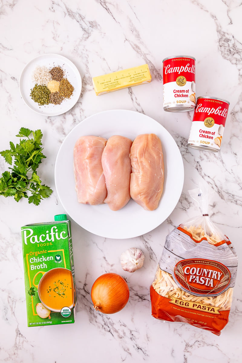 Ingredients for crockpot chicken and noodles laid out on counter in bowls in prepration for the recipe.