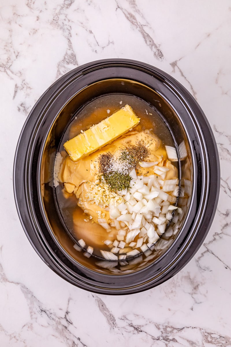 Next set of ingredients is added to the crockpot on top of the chicken.