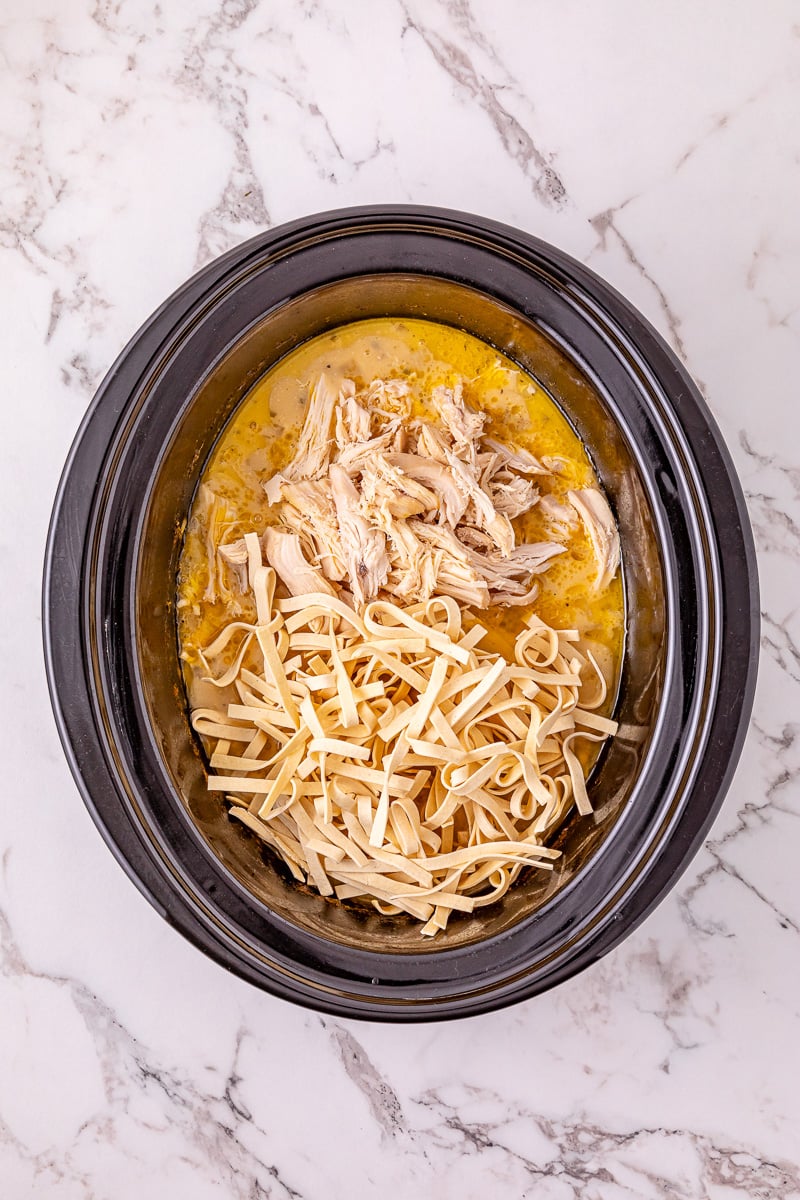 Chicken is returned to the crockpot along with the noodles.