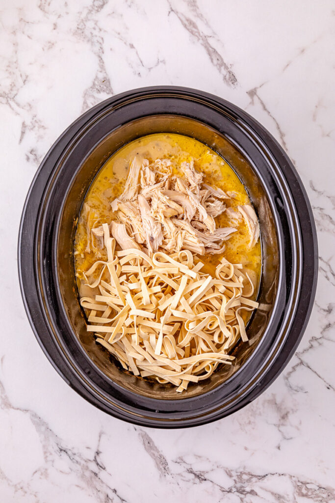 Noodles and shredded chicken are added back to the crockpot.