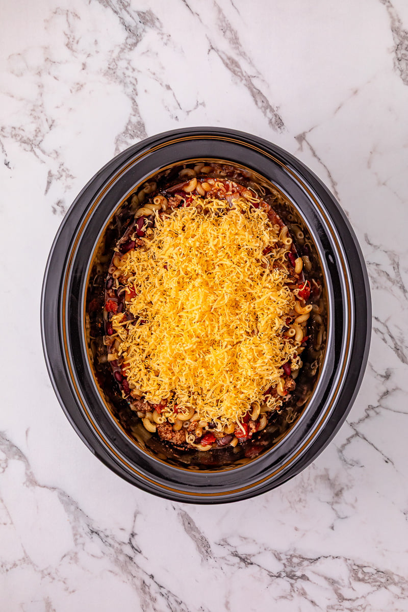Shredded cheddar cheese is added to the crockpot.
