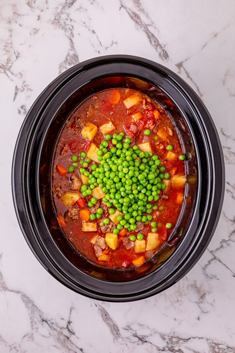 Pease are added to the crockpot.