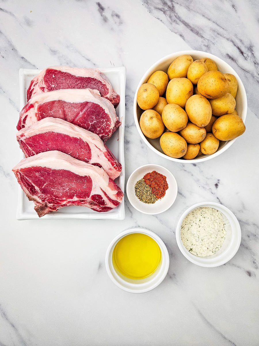 Ingredients for sheet pan pork chops and potatoes laid out on kitchen counter.