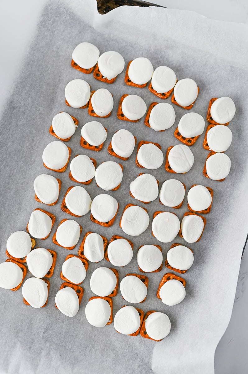 Marshamallow on top of pretzel snaps on baking sheet.