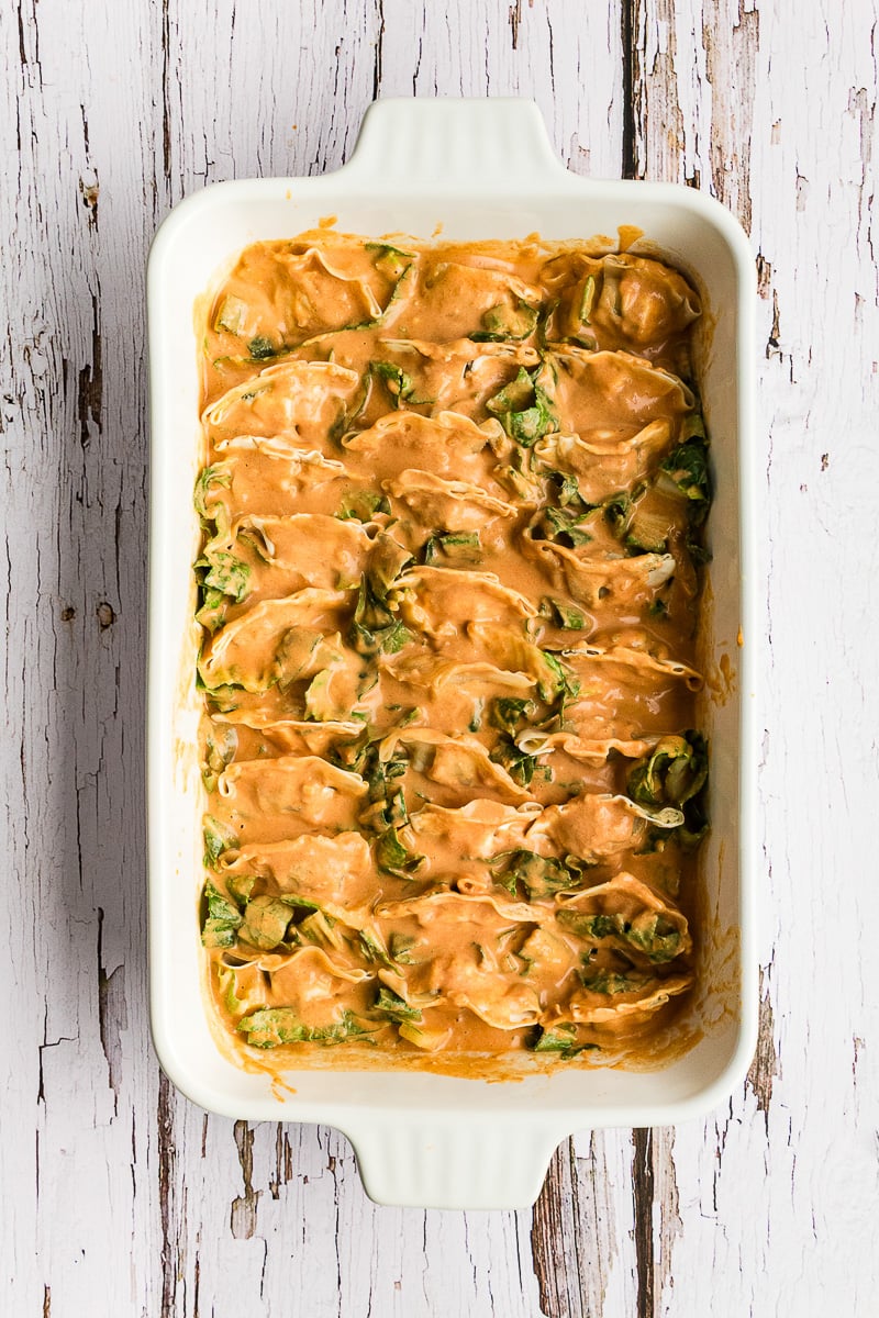 Sauce is spooned over dumplings in baking dish.