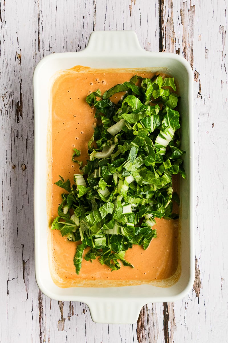 Bok choy is added to the mixed ingredients.