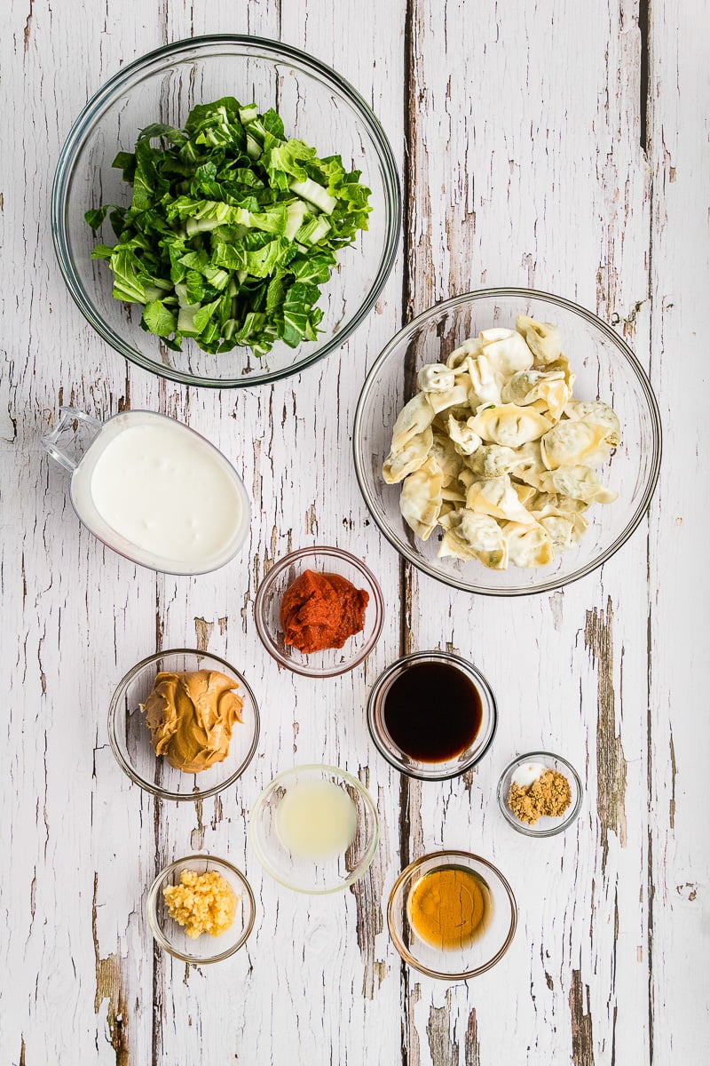 Ingredients for viral dumpling bake placed in small bowls on kitchen counter to prepare for making the recipe.
