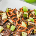 Caramel apple bark cut and placed on a white plate for serving.