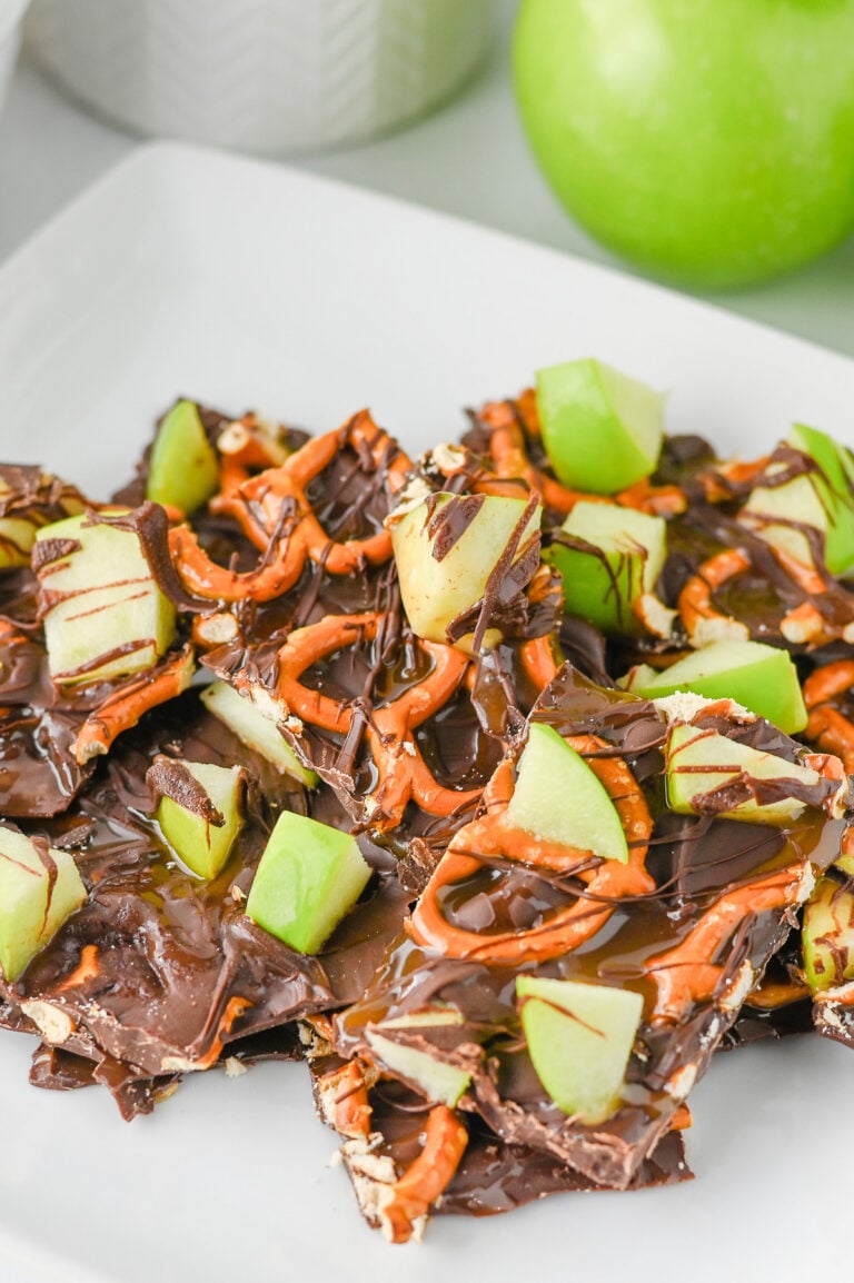 Caramel apple bark cut and placed on a white plate for serving.