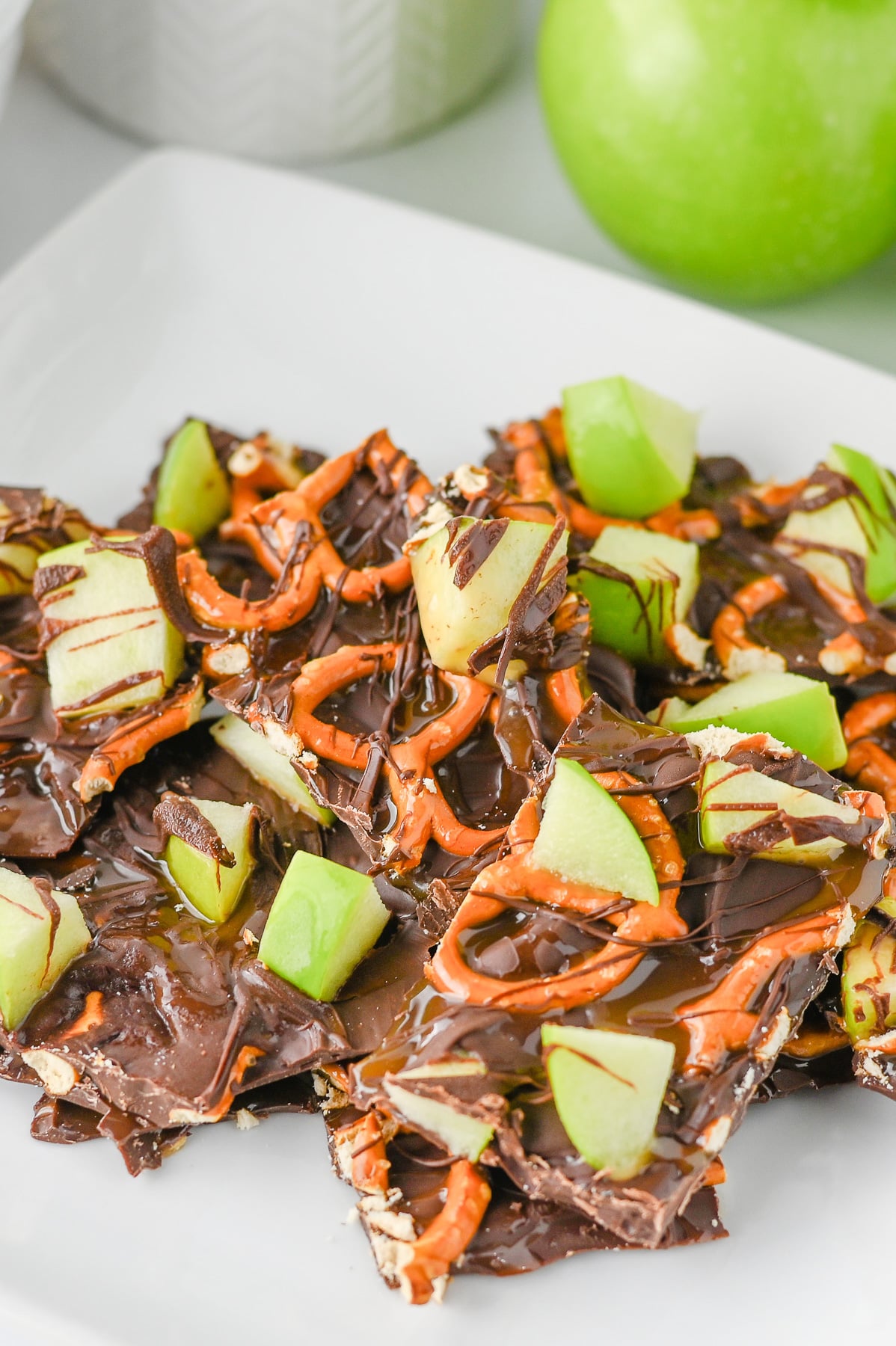 Caramel apple bark cut and placed on a white plate for serving.