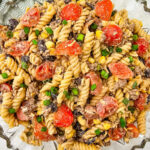 Cowboy pasta salad with ground beef and bacon in a glass bowl for a backyard bbq party.
