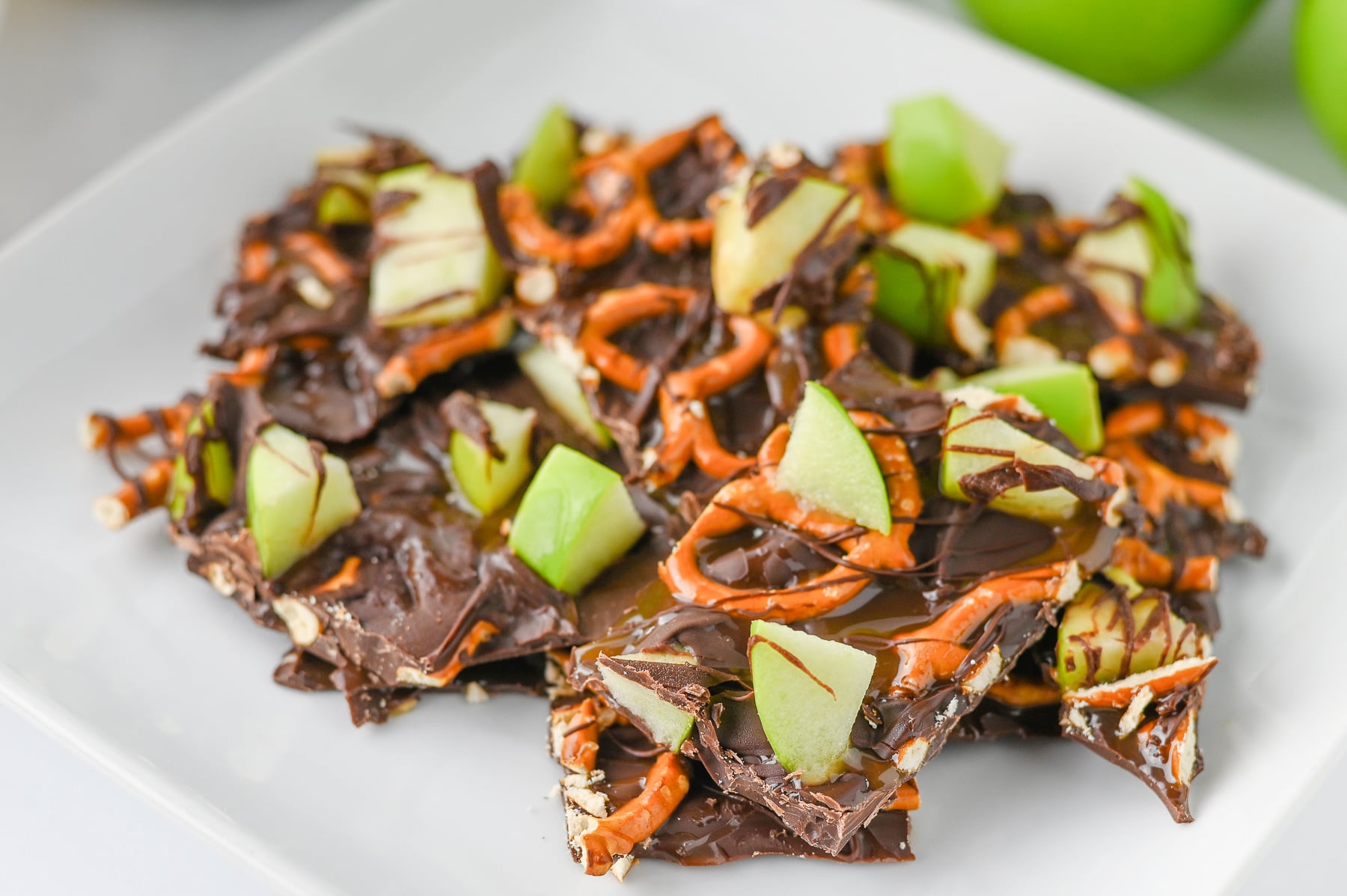 Caramel apple bark on white plate.