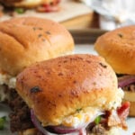 Jalapeno popper burgers sliders on a white plate.