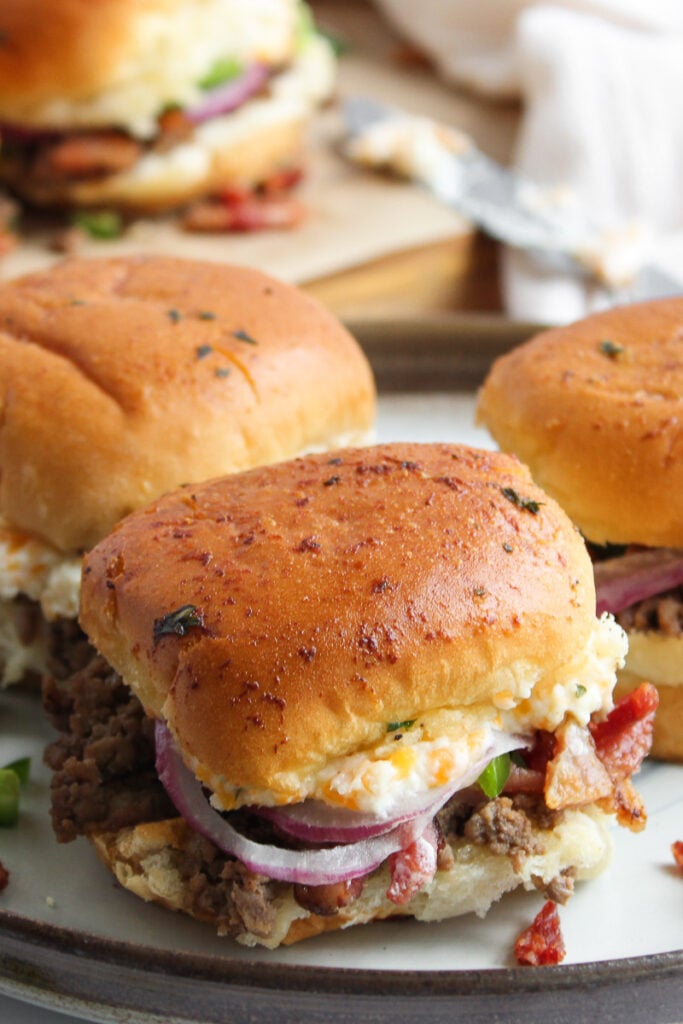 Jalapeno popper burgers sliders on a white plate.