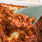 Cowboy baked beans scooped up on spooon.