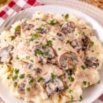 Crockpot creamy mushroom chicken served on a plate with mashed potatoes.