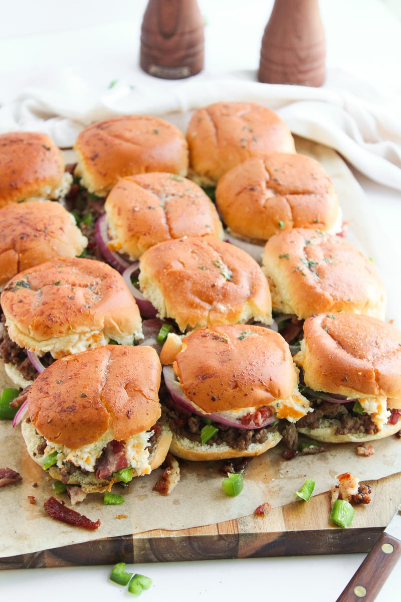 Jalapeno popper burger sliders on serving board for a game day party.