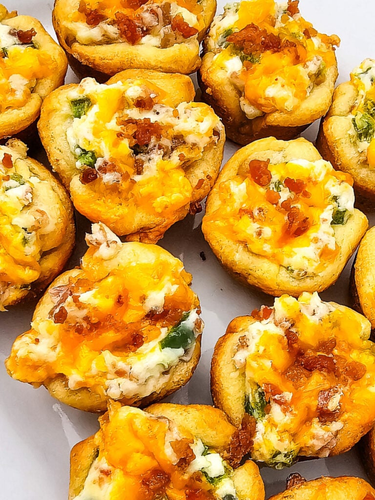 Jalapeno bacon crescent roll bites on a white plate.