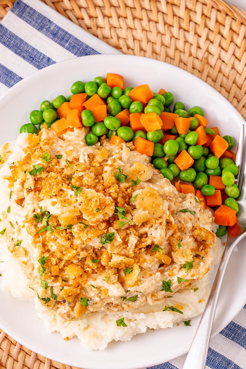 Ritz cracker chicken on a plate with mashed potatoes and mixed vegetables.