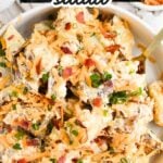 Loaded baked potato salad served in a white bowl.