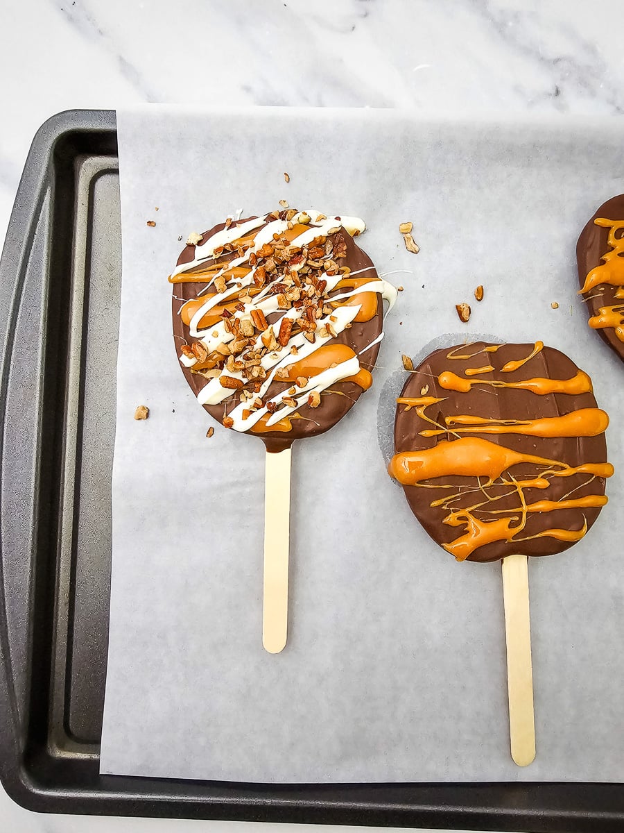 White chocolate is drizzled on top of the apple slices, followed by the chopped pecans.