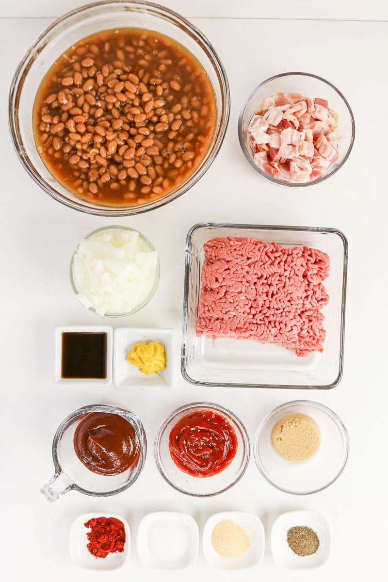 Ingredients for cowboy baked beans in small bowls on kitchen counter in preparation for the recipe.