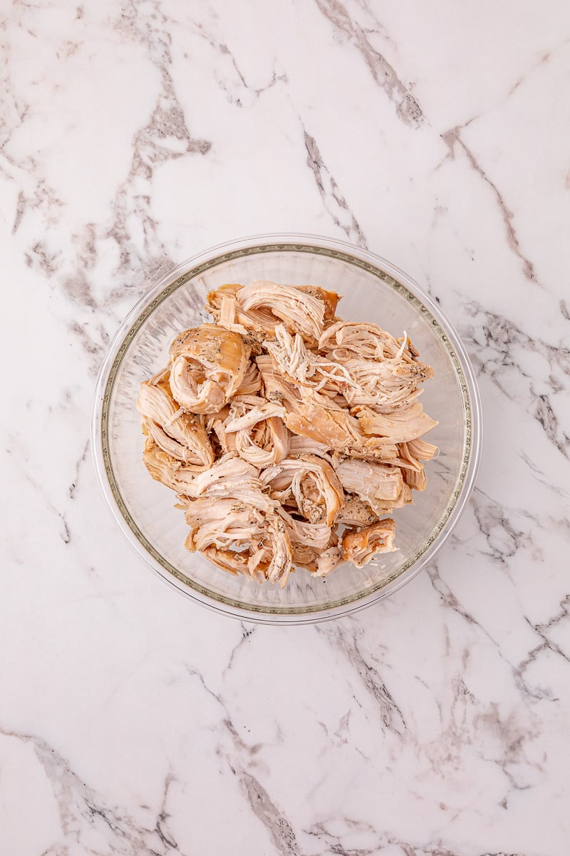 Shredded chicken in a glass bowl.