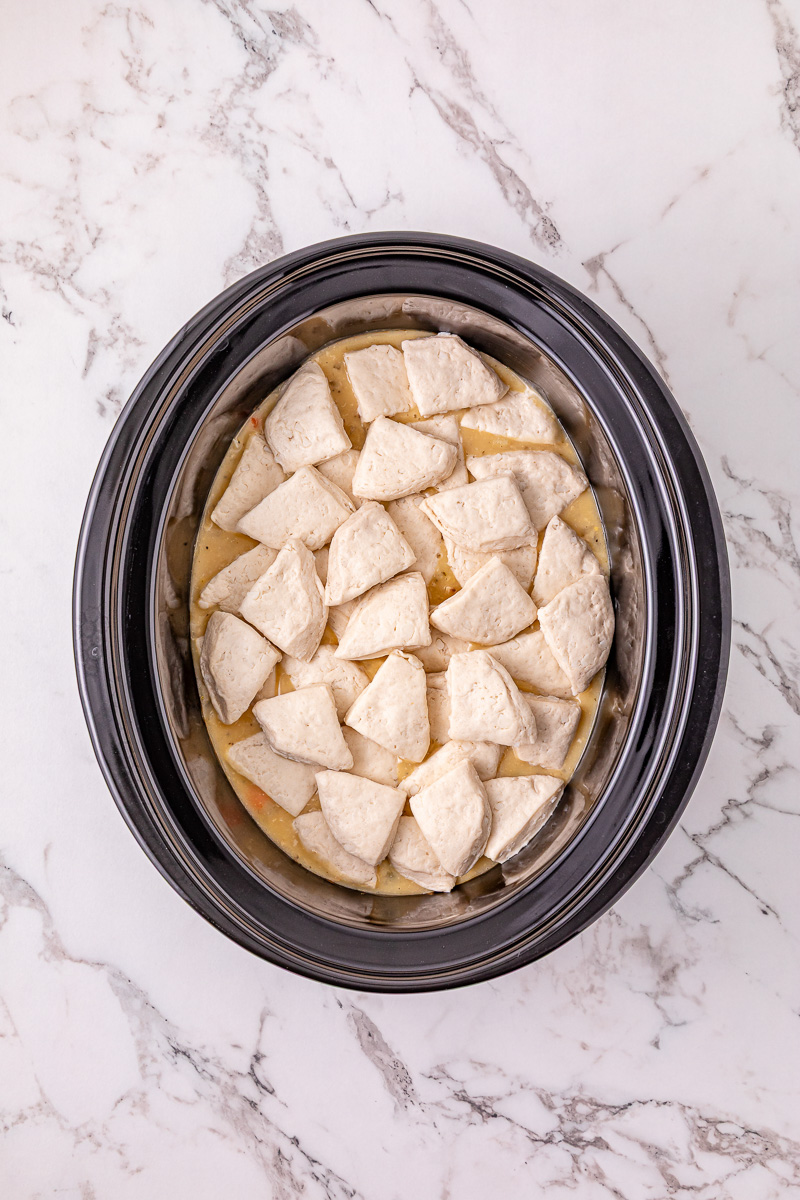Biscuit pieces are added to the crockpot.